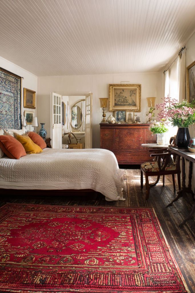 This vintage bedroom features a beautiful blend of dark brown antique furniture,and a red turkish rug giving it a warm and timeless vibe.