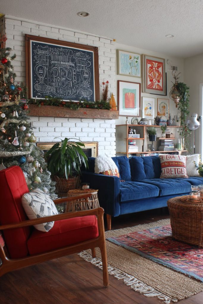 Retro Christmas living room with navy sofa, red armchair, white brick fireplace, colorful wall art, and eclectic holiday decor.