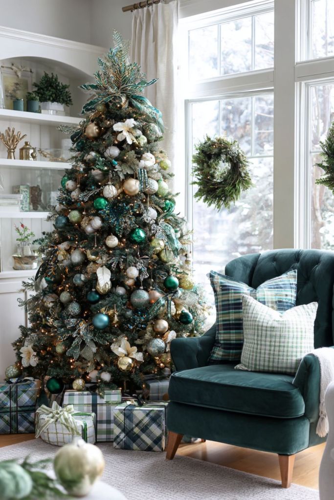 Green and gold Christmas living room with a decorated tree, plaid pillows, green velvet chair, and wrapped gifts in matching tones.